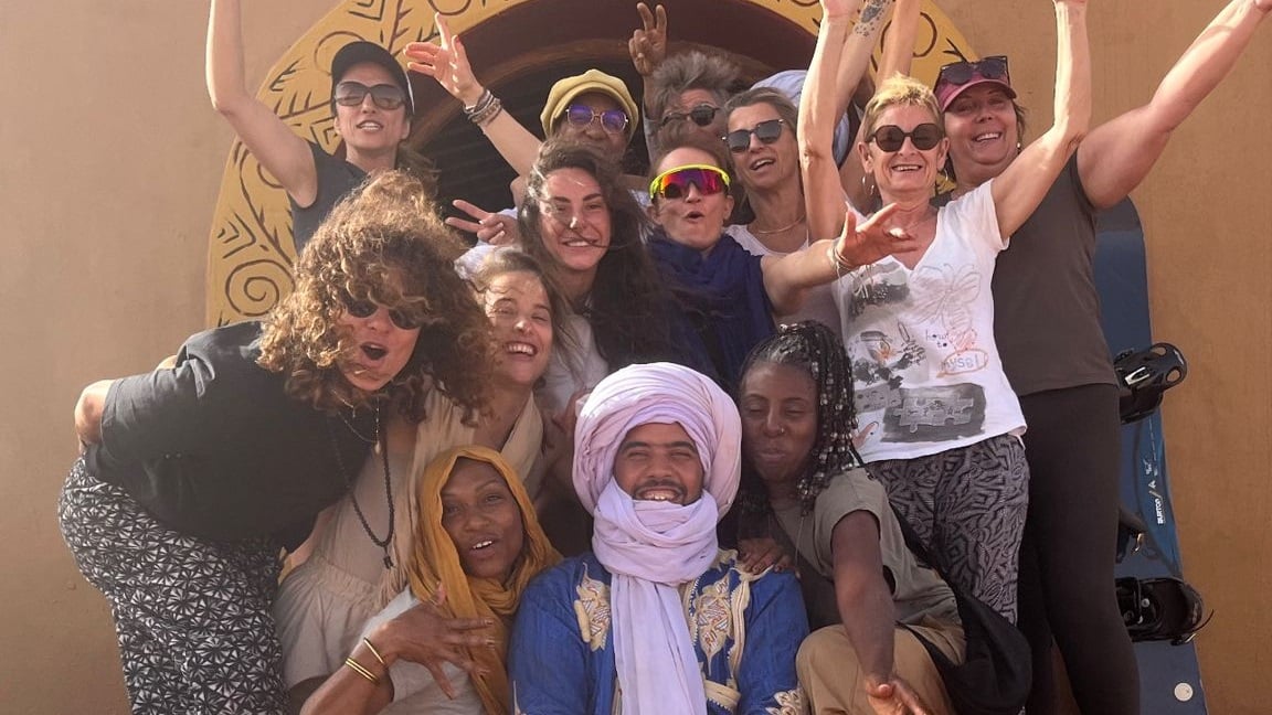 photo de groupe avec un guide nomade devant une porte marocaine.