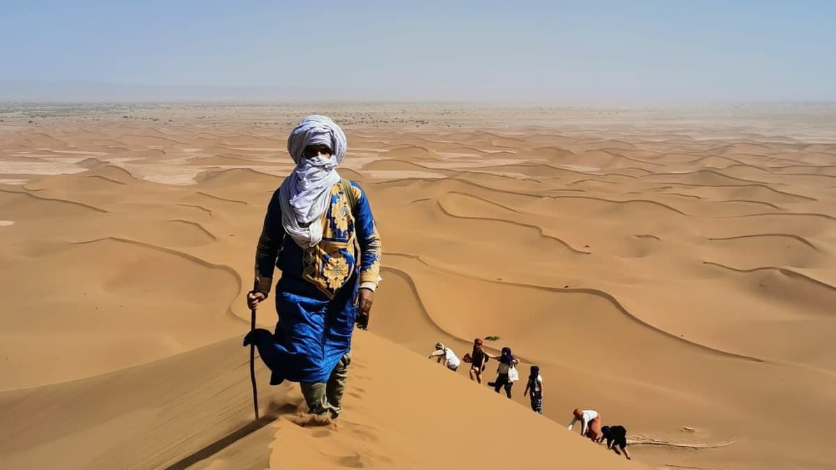 Un portrait d'un nomade grimpant la grande dune