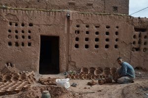 Un potier devant une poterie artisanale à Tamegroute