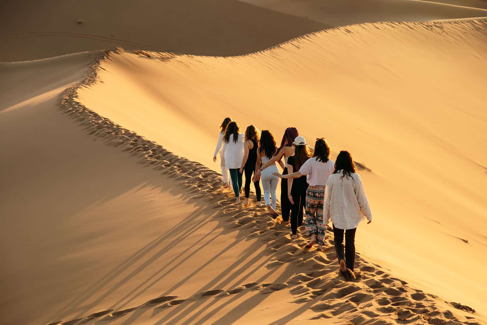 Un groupe de femmes marchent sur la crête de la dune